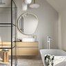 Ein modernes Badezimmer mit einer eleganten Badewanne, einem Holzwaschtisch und einer großen, runden Spiegelfläche.